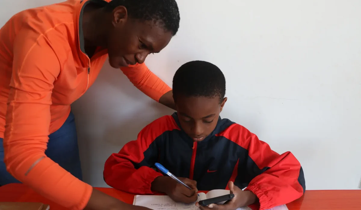 ConnectEd-07 A student works on math problems, guided via SMS by his tutor and assisted by a guardian. Courtesy of ConnectEd.
